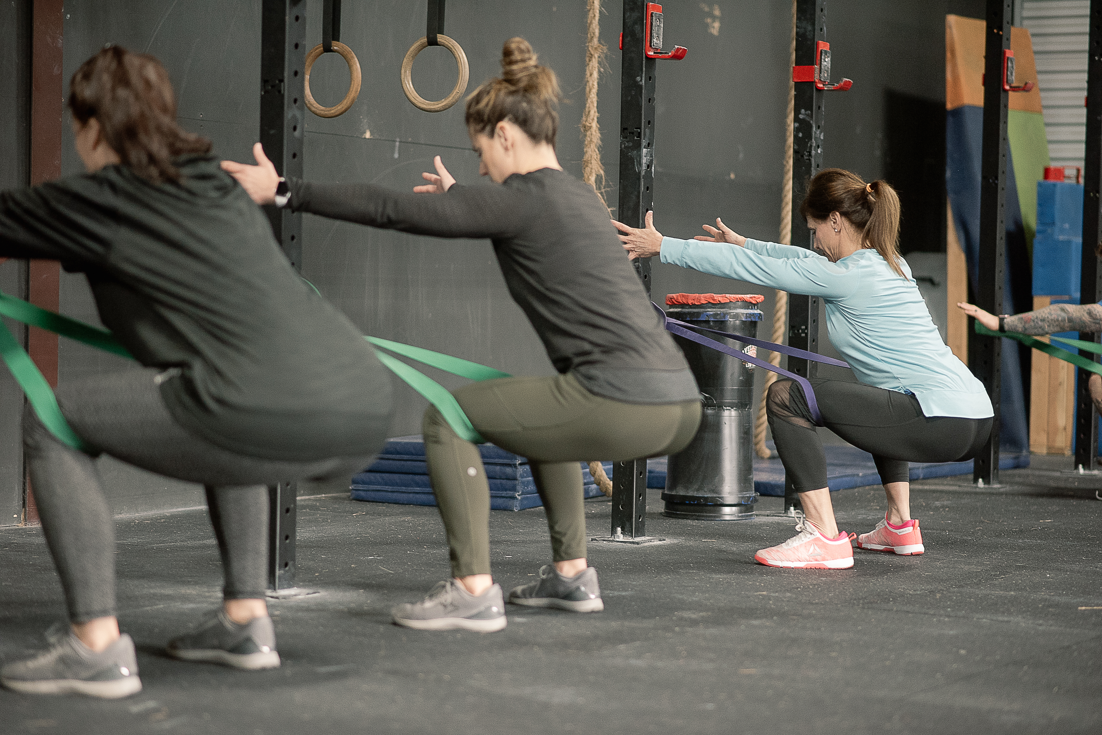 Small group of women doing banded squats in a FitRx class